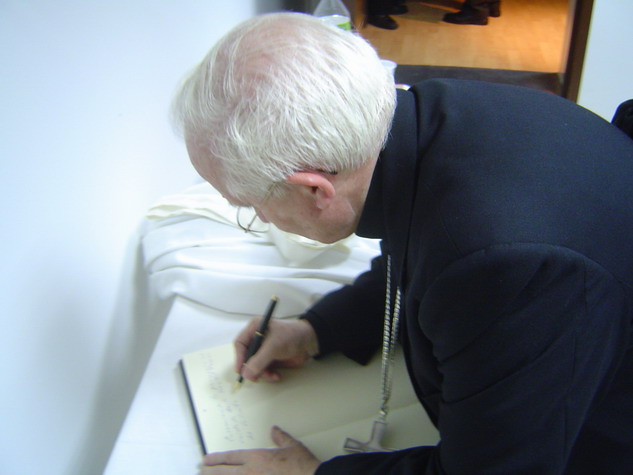 008.jpg - El Cardenal firmando en el libro de visitas